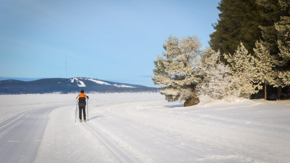 Hiihtäjä Sapsojärvellä Vuokatinvaarat taustalla.